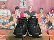 Front view of black lace-up sneakers showing textured uppers, padded tongues, and white speckled midsole sections.