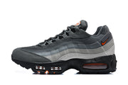 Side profile of a grey Nike Air Max 95 TT sneaker with orange accents and visible air-cushion windows