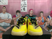 Front view of yellow basketball shoes with black laces and dark accents