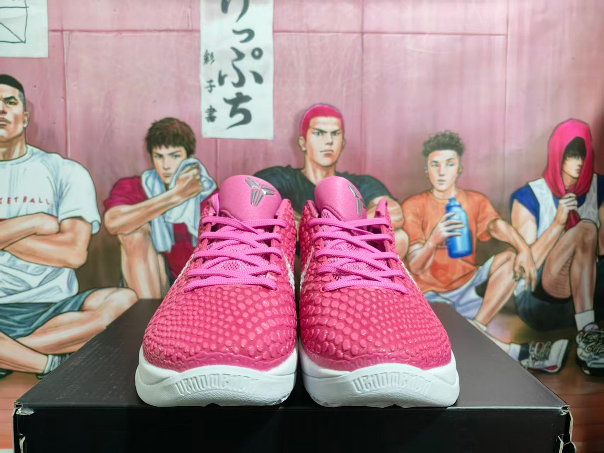 Front view of pink and white Nike basketball sneakers on a black box, with a textured pink upper and LeBron-style tongue branding.