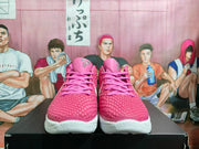 Front view of pink and white Nike basketball sneakers on a black box, with a textured pink upper and LeBron-style tongue branding.
