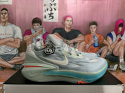 Side view of a grey Nike basketball sneaker showing the Swoosh, layered heel structure, and blue-green outsole.