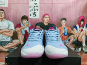 Front view of the pair showing light blue laces, white textured toe panels, pink Jumpman logos and purple translucent outsoles.