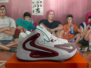 Side profile of a white Nike basketball sneaker with a large burgundy Swoosh, burgundy outsole, and visible Just Do It text.
