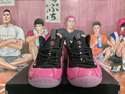 Front view of pink and black high-top basketball shoes with black laces and tongue details.