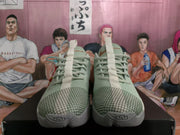 Front view of pale green Nike basketball sneakers showing laces, textured uppers, grid-patterned toe panels, and ribbed toe outsoles.