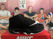 Side profile of a black high-top Nike basketball sneaker showing the white Swoosh, sculpted black midsole, and white outsole edge.