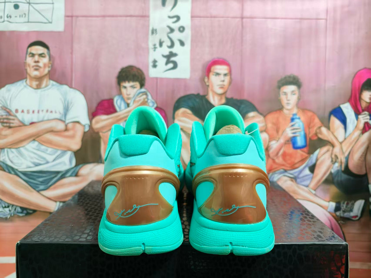 Rear view of turquoise Nike Kobe basketball sneakers with bronze heel panels and a basketball-themed background.