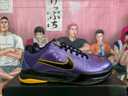 Side profile of a purple Nike basketball sneaker with black laces, a black-and-yellow swoosh, and a yellow outsole.