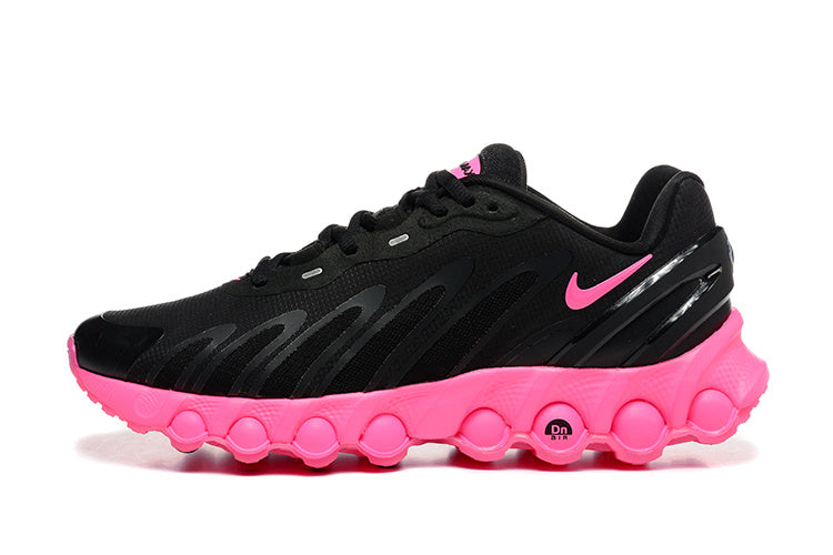 Side view of black sneakers with pink accents and a sculpted pink bubble-pattern sole