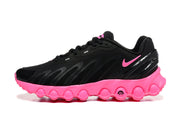 Side view of black sneakers with pink accents and a sculpted pink bubble-pattern sole