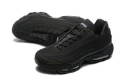Pair of black Nike Air Max 95 sneakers with A Ma Maniére tongue branding.