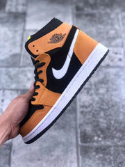 Close side profile showing the orange ankle panel, winged basketball emblem, white Swoosh, and black outsole.