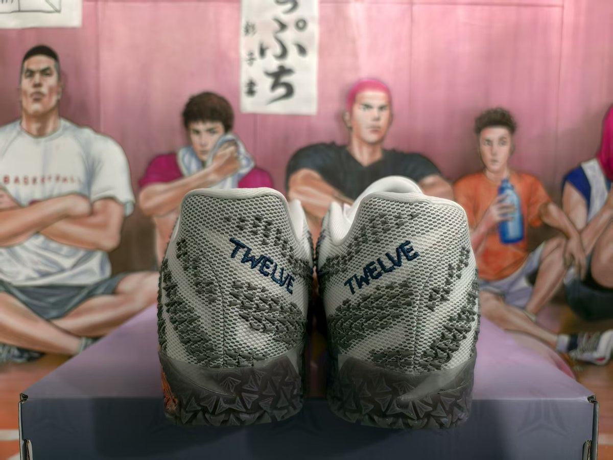 Rear view of white and gray Nike basketball sneakers showing patterned uppers, dark heel sections, and geometric outsoles.