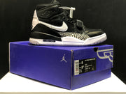 Side view of a black and white high-top sneaker displayed on its matching box; the box label shows Air Jordan Legacy 312 and size information.