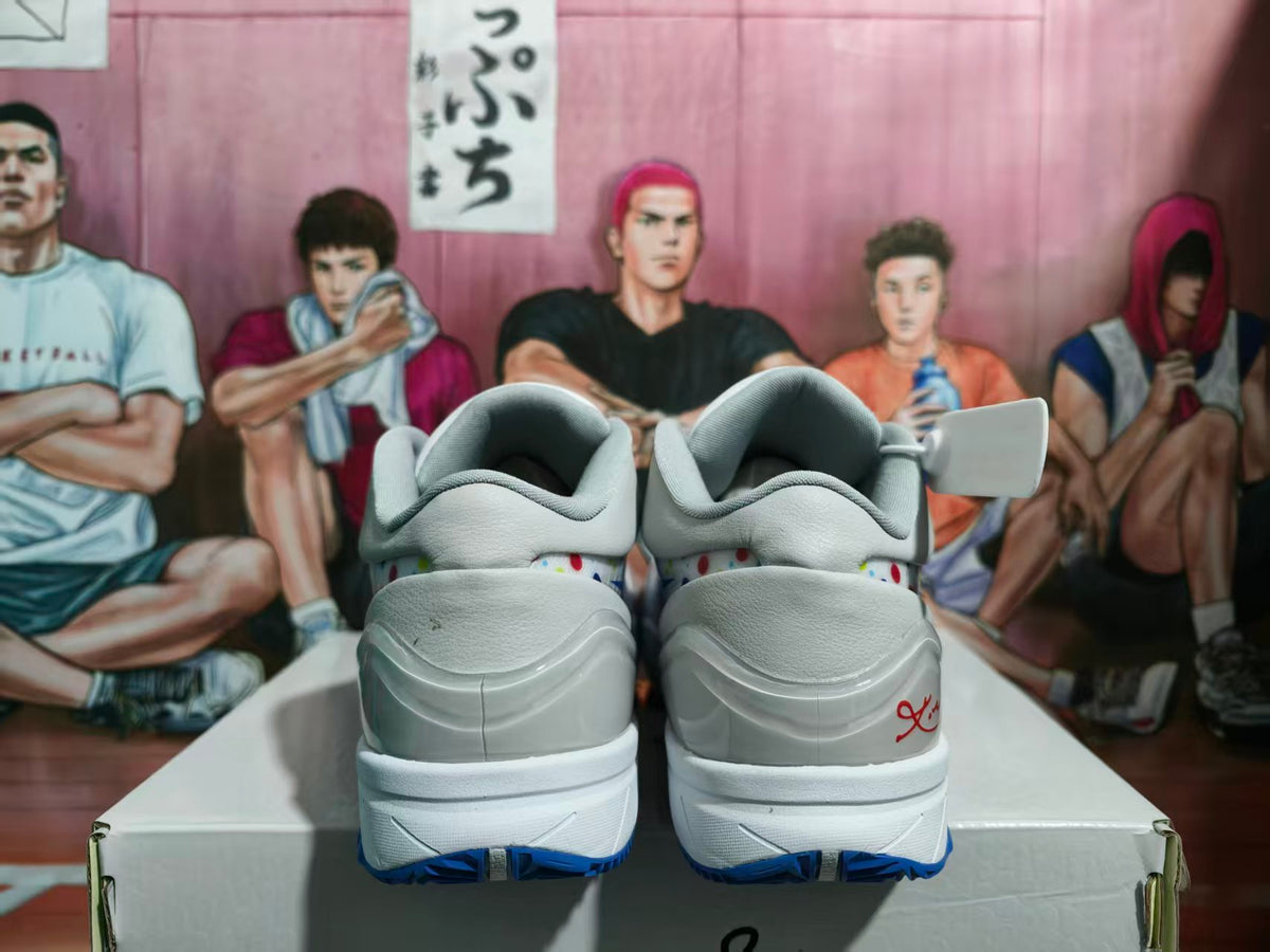 Rear view of gray and white Nike basketball sneakers with blue outsole accents and red heel detailing.