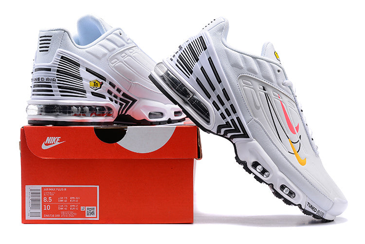 White Nike Air Max Plus sneakers with black accents and pink and yellow graphics, displayed on a red shoe box.