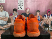 Rear view of orange basketball shoes showing sculpted heels and signatures.