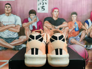 Rear view showing the black-and-white heel graphics and light midsoles with small orange accents.