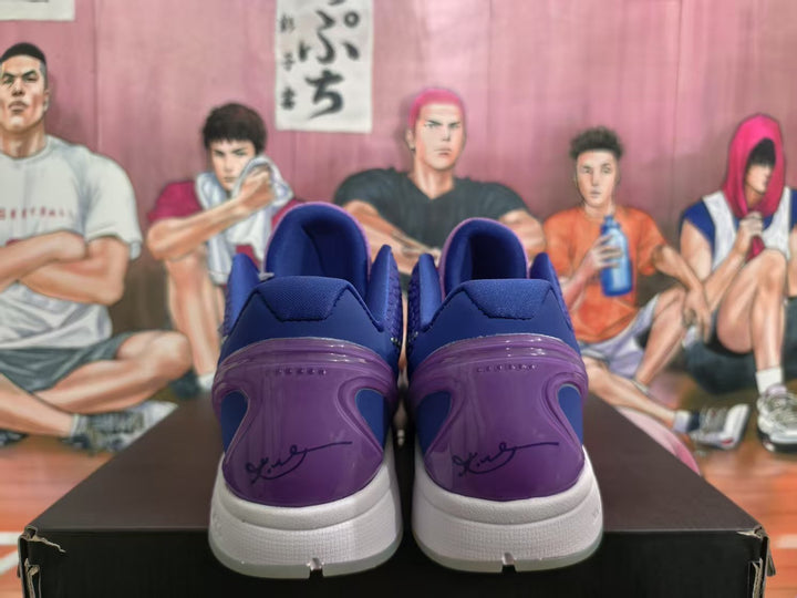 Rear view of purple and blue Nike basketball sneakers with white midsoles, displayed on a black shoebox.