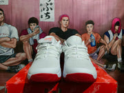 Front view of the white Nike basketball shoes with red outsole accents.