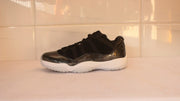 Side profile showing the low-top shape, black upper, dark metallic-look lower panel and white outsole.