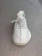 Front-top view showing the laces, knit-look upper, reflective-looking tongue area, and rounded toe.