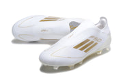 Pair of white and gold-colored adidas F50 laceless soccer cleats shown from above and at an angle.