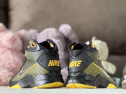 Rear view of the pair showing Nike branding on the heel panels and yellow outsole details.