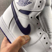 Close-up of the purple side Swoosh, white upper panels, eyelets, and visible stitching.