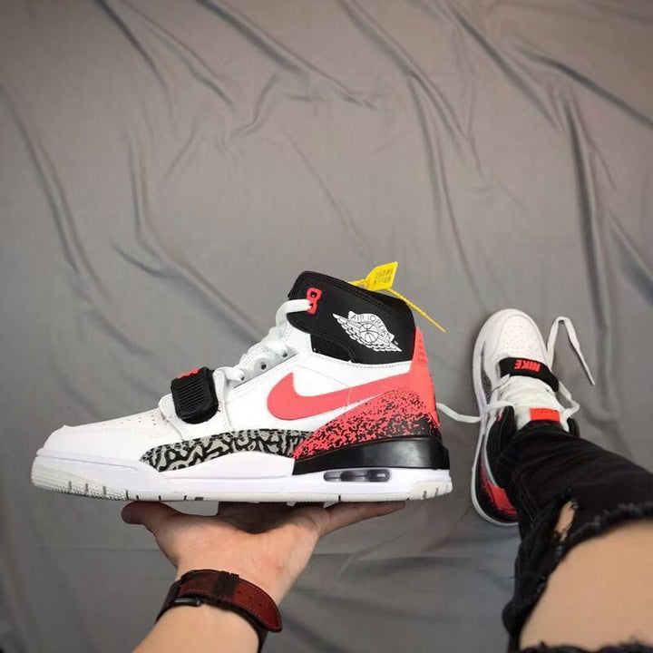 Side view of a white, black, and red high-top sneaker with a forefoot strap, elephant-print panel, and visible midsole window.