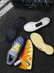Top and outsole views of the yellow and blue sneakers arranged on a dark surface.