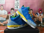 Pair of blue and yellow Jordan 3 sneakers shown at an angle