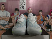 Pair of light blue and white basketball sneakers shown from the front on a shoe box.