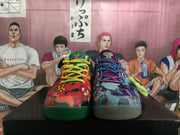 Front view of mismatched multicolor Nike basketball shoes with different graphic designs and lace colors.