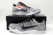 Pair of black-and-white low-top sneakers displayed on a shoebox