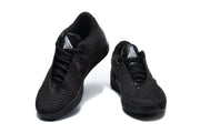 Front view of black Nike Metcon shoes with lace-up closures and silver tongue logos.