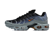 Side view of black and grey Nike Air Max Plus sneakers with orange accents