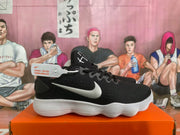 Side profile of a black Nike sneaker with silver logo and white ridged sole.