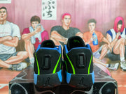 Rear view of black Jordan basketball shoes with blue and volt-green accents.
