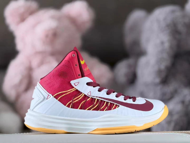 Side view of a white, red, and yellow Nike Hyperdunk 2012 kids basketball shoe