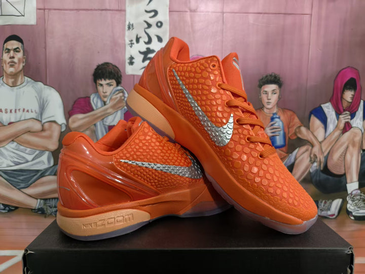 Pair of orange Nike Zoom sneakers displayed on a black box, showing the textured upper, silver Swoosh, and sculpted heel.