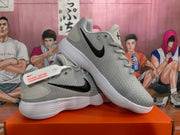 Angled view of gray Nike sneakers showing the black Swoosh, gray upper, laces, and white soles.