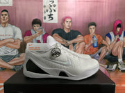Side view of a white Nike basketball sneaker showing the Swoosh, Kobe-associated side graphic, and black midsole section.