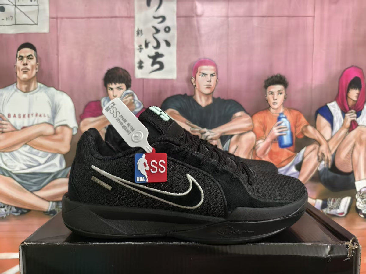 Black Nike basketball sneakers shown in profile on a shoebox, with a white Swoosh and NBA tag visible.