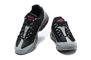 Front view of a pair of Nike Air Max 95 TT sneakers in black and grey with red details.