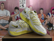 Angled view showing the side panels and black Swoosh details on white and yellow Nike shoes