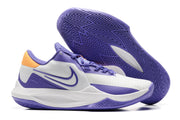 White and purple basketball shoe with orange heel details and a purple outsole.