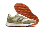 Side view of the sneakers with the orange-brown outsole facing upward