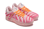Three-quarter front view of the pink sneakers with orange laces, textured panels, and padded collars.